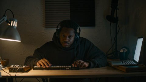 The 2 AM Problem: Why Your Best Session Sounds Different in the Morning 7 Independent artist working alone at a home studio desk late at night, lit only by a desk lamp and the glow of a laptop