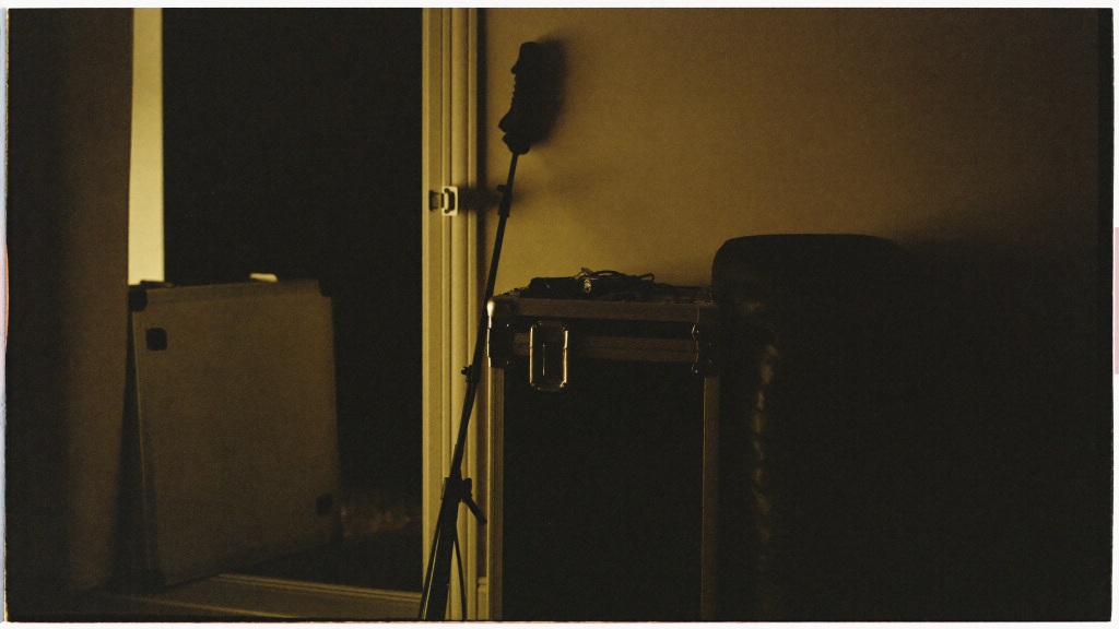 A hard flight case and gear bag stacked by a doorway at night with car keys resting on top